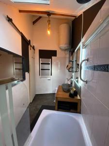 ein Badezimmer mit einer großen Badewanne und einem Waschbecken in der Unterkunft Petit duplex cocooning in Férel