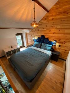 ein Schlafzimmer mit einem großen Bett in einem Holzzimmer in der Unterkunft Petit duplex cocooning in Férel