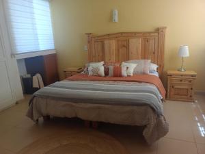 a bedroom with a large bed with a wooden headboard at GoBaja Villas 3 bedroom in La Paz