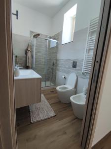 a bathroom with a toilet and a tub and a sink at Country House Ortensie in Torre del Greco