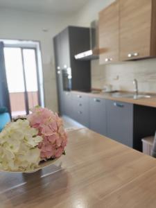 a vase of flowers sitting on a table in a kitchen at Country House Ortensie in Torre del Greco