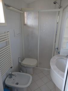 Baño blanco con aseo y lavamanos en Casa Belvedere, en Citerna