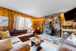 a living room with a couch and a stone fireplace at Rockhouse Mountain Retreat in Conway