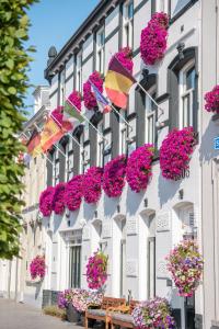 un edificio con flores y sombrillas. en Hotel Old Dutch Bergen op Zoom, en Bergen op Zoom