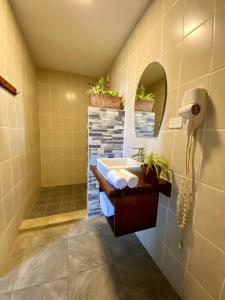 uma casa de banho com um lavatório e um chuveiro com plantas em JAKES ON THE BEACH em Las Peñitas