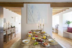 a dining room with a table filled with food and candles at East Cornworthy Barton in Totnes