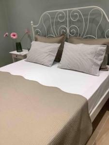 a large bed with a metal headboard and pillows at N G Luxury Apartments at Nea Kallikrateia No 2 in Nea Kallikrateia