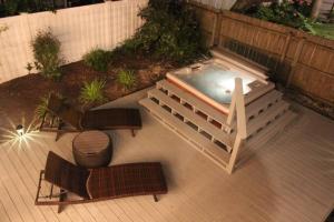 uma banheira de hidromassagem num pátio com 2 cadeiras e uma mesa em Croatan Beach House - Big Kitchen, Hot Tub, 2 Masters em Virginia Beach