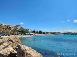 a beach with rocks and people in the water at N G Luxury Apartments at Nea Kallikrateia No 2 in Nea Kallikrateia