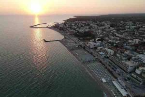 an aerial view of a beach with the sun setting over the water at N G Luxury Apartments at Nea Kallikrateia No 2 in Nea Kallikrateia