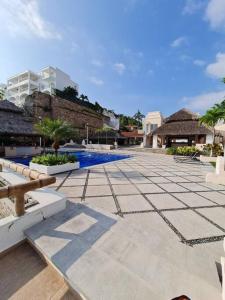 un patio con piscina y un edificio en 2 Bedroom 2 bathroom condo pool, tennis beach club, en Manzanillo