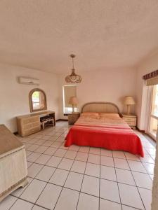 1 dormitorio con 1 cama con colcha roja. en 2 Bedroom 2 bathroom condo pool, tennis beach club, en Manzanillo