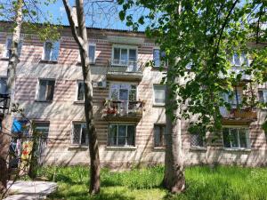 a brick building with windows and trees in front of it at Квартира in Bender