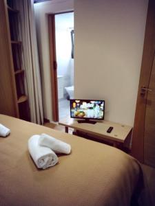 アヴェイロにあるGreen Houseのベッドとテレビが備わるホテルルームです。