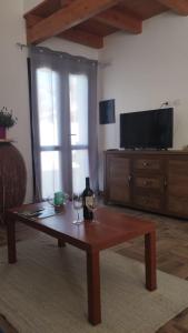 - un salon avec une table basse et une télévision dans l'établissement casa vacanza Il Delfino, à Torre Grande