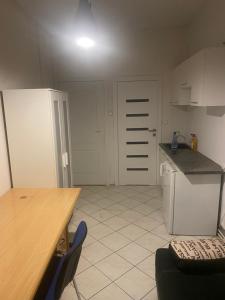 a kitchen with white cabinets and a table and a counter at Fałata apartament in Kobyłka