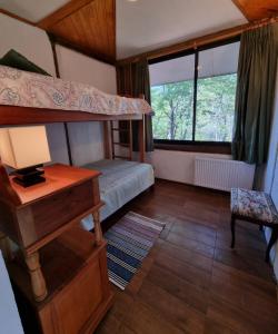 a bedroom with a bunk bed and a desk at Casa Ayllantú in Las Trancas