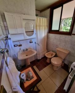 a bathroom with a toilet and a sink and a toilet istg at Casa Ayllantú in Las Trancas
