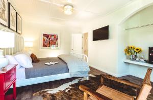 a bedroom with a bed and a desk and a tv at Stables Inn in Paso Robles