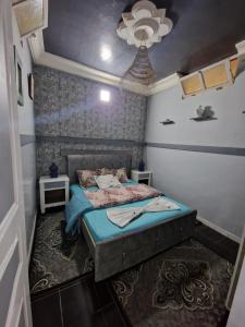 een kleine slaapkamer met een bed met een blauw dekbed bij Dar Salma in Sousse