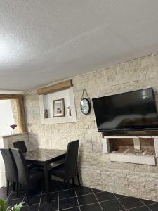 a dining room with a table and a television on a wall at Apartman Hana in Brtonigla