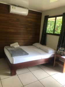 a bedroom with a bed with a wooden wall at Le Petit Hotel in Fortuna