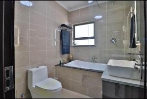a bathroom with a toilet and a sink and a tub at Fully furnished apartment. in Sandton