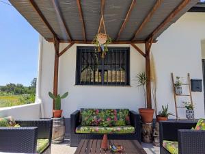 a patio with a couch and chairs and a window at Casa rural Chapinheira in Chapinheira