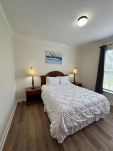 ein Schlafzimmer mit einem großen Bett und zwei Lampen an Tischen in der Unterkunft Florida Vacation Condo - No Resort Fees in Kissimmee