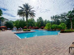 a swimming pool with a palm tree in a resort at Florida Vacation Condo - No Resort Fees in Kissimmee
