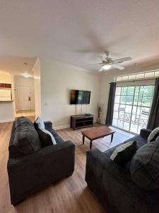 een woonkamer met 2 banken en een flatscreen-tv bij Florida Vacation Condo - No Resort Fees in Kissimmee