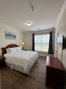 sypialnia z dużym łóżkiem i oknem w obiekcie Florida Vacation Condo - No Resort Fees w mieście Kissimmee