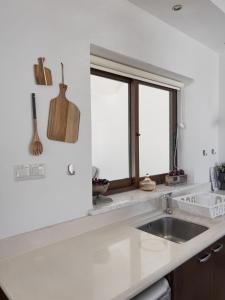 a white kitchen with a sink and a window at Leo's Paradise in Protaras