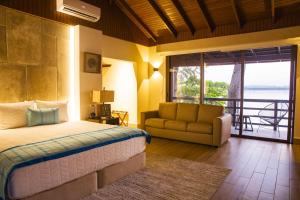 - une chambre avec un lit, un canapé et une fenêtre dans l'établissement G Boutique Hotel at San Andres Peten, à San Andrés