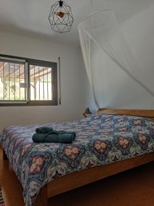 a bedroom with a bed with a comforter and a window at Casa rural Chapinheira in Chapinheira