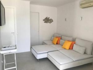 a living room with a white couch with colorful pillows at Costa Ilios 3 Bedroom Flat in Ornos