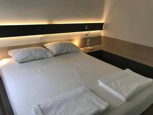 a large white bed with two pillows on it at Costa Ilios 3 Bedroom Flat in Ornos