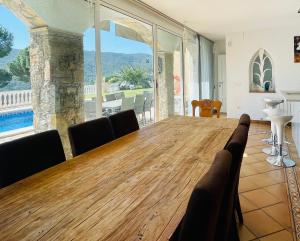 ein Esszimmer mit einem großen Holztisch mit Stühlen in der Unterkunft Villa reina by costabravaway in Calonge
