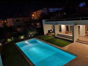 a swimming pool in front of a house at night at Villa L in Galé