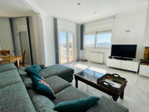 ein Wohnzimmer mit einem Sofa, einem Tisch und einem TV in der Unterkunft Villa reina by costabravaway in Calonge