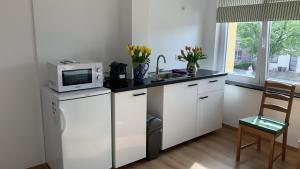 a kitchen with white cabinets and a microwave on a counter at Orange Dolce in Zaventem