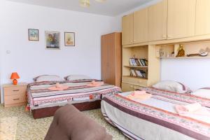 a bedroom with two beds and a chair in it at Vila Vojvođanka in Soko Banja