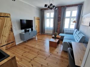 sala de estar con sofá azul y TV en Apartamenty w ścisłym centrum Kupiecka-Drzewna, en Zielona Góra