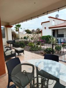 a patio with a table and chairs and a fence at GoBaja Villas 2 bedroom in La Paz