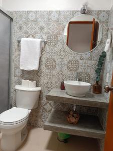 y baño con aseo, lavabo y espejo. en GoBaja Villas 2 bedroom en La Paz