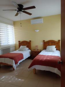 a bedroom with two beds and a ceiling fan at GoBaja Villas 2 bedroom in La Paz