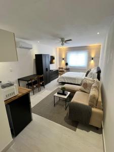 sala de estar con cama y sofá en Suites By SalcedO, en Santo Domingo