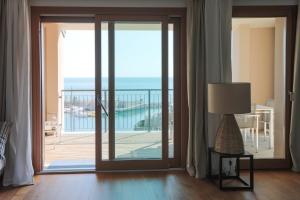 a room with a sliding glass door leading to a balcony at Portopiccolo Avolare Apartments in Sistiana