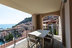 balcón con mesa y vistas al océano en Portopiccolo Avolare Apartments, en Sistiana