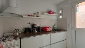una cucina bianca con fornelli e lavello di Casa Brava a Puerto Pirámides